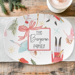 May include: White oval serving platter with a festive Nutcracker and ballerina design. The platter features a red bow, snowflakes, and the text "The Bergeron Family" in a decorative font. A holiday-themed serving dish.