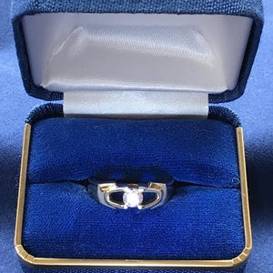 Gold alloy ring with 1/2 carat cubic zirconia solitaire stone.