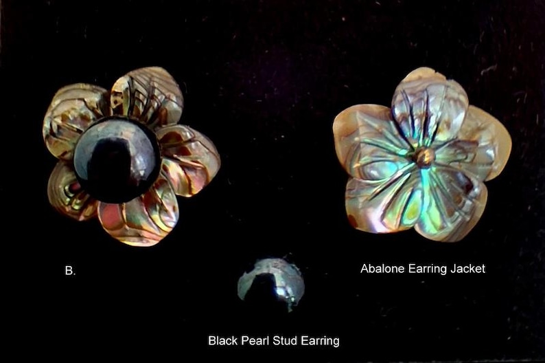 Pu&ograve; includere: Un orecchino a perno con perla nera e un copri-orecchino in abalone a forma di fiore a cinque petali. Il copri-orecchino presenta texture di conchiglia iridescenti e multicolori. Il testo B, Abalone Earring Jacket e Black Pearl Stud Earring &egrave; visibile.