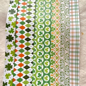 May include: Eight strips of patterned paper with a St. Patrick's Day theme. The patterns include shamrocks, diamonds, and Celtic knots. The colors are green, white, orange, and black.