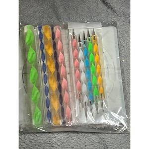 May include: A set of crafting tools including four clear acrylic rods with internal spiral designs in green, blue, yellow, purple, and pink, alongside five metal-tipped dotting styluses with colorful spiral handles in pink, white, blue, green, and yellow.