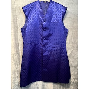 May include: A sleeveless, button-down vest in a vibrant blue hue. The vest features a repeating square pattern across the fabric. It has a V-neck and two front pockets. The vest is made of a shiny material.