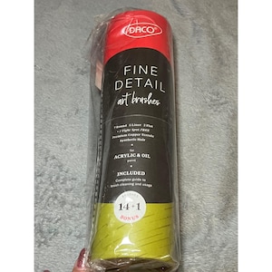 May include: A cylindrical package of Daco fine detail art brushes wrapped in clear plastic. The label features red, black, and lime green sections with text detailing 7 round, 5 liner, and 2 flat brushes, plus 1 tight spot brush, copper ferrules, and synthetic hair for acrylic and oil paint.