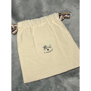 May include: Cream-colored drawstring bag with the "IL BISONTE" logo in black. The bag has a simple design with a drawstring closure and decorative ribbon ties in brown, white, and navy blue.