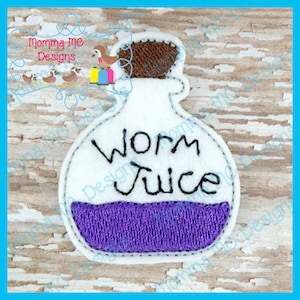 May include: A white felt patch in the shape of a bottle, with the words "Worm Juice" in black. The bottle contains a purple liquid and has a brown cork. The patch is outlined with white stitching and has a light blue border.