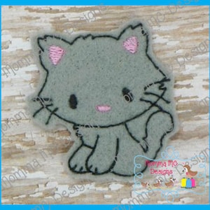 May include: A gray embroidered applique of a cartoon cat with pink ears and nose. The cat is sitting with its legs tucked under its body.