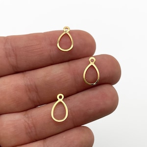 May include: Three gold-colored metal teardrop-shaped pendant charms with a loop at the top.