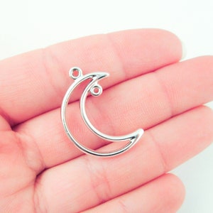 以下が含まれることがあります： 銀色の三日月形のチャーム。2つのジャンプリングが付いており、ジュエリーやその他のクラフトに付けることができます。