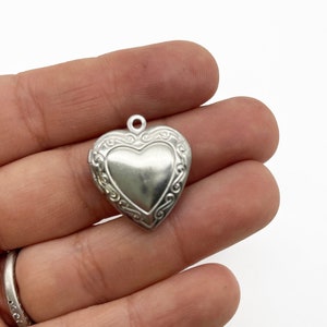 2 Stainless Steel Heart Lockets With Decorative Patterns On The Front D19