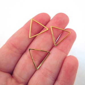 May include: Three gold triangle shaped metal hoops. The hoops are open and can be used for jewelry making.