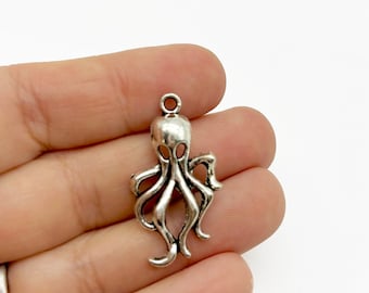 May include: Silver-toned octopus charm with a detailed design. The charm has a loop at the top for attaching to jewelry or other crafts.