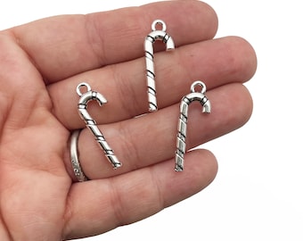 Op de afbeelding: Drie zilverkleurige snoepstok-bedels met een swirl-ontwerp. De bedels hebben een lus aan de bovenkant om aan sieraden of andere knutselwerkjes te bevestigen.