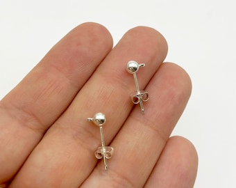 Puede incluir: Dos postes de pendientes de plata con una pequeña bola en la parte superior. Los postes están diseñados para ser usados con una variedad de encantos de pendientes.