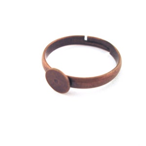 May include: A copper ring with a round bezel for a cabochon.