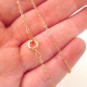 May include: A gold chain necklace with a lobster clasp closure.