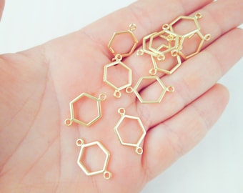 Pode incluir: Uma coleção de pingentes conectores hexagonais dourados. Cada pingente tem uma forma geométrica com pequenos laços nos cantos para fixar a outros componentes. Ideal para fazer joias ou projetos de artesanato.