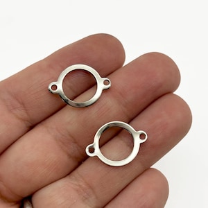 May include: Two small, silver-colored metal circle connectors with a circular opening and two small holes on either side. The connectors are shown against a neutral background.