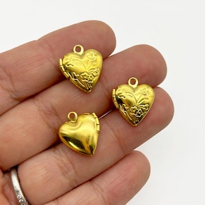 May include: Three gold-colored heart-shaped lockets. Each locket has a small loop at the top for a chain. The lockets have a floral design on the front and open to reveal a space for a small photo or keepsake.