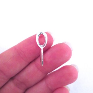 May include: Silver oval pendant bail with a loop on the bottom. The bail is designed to hold a pendant or charm.
