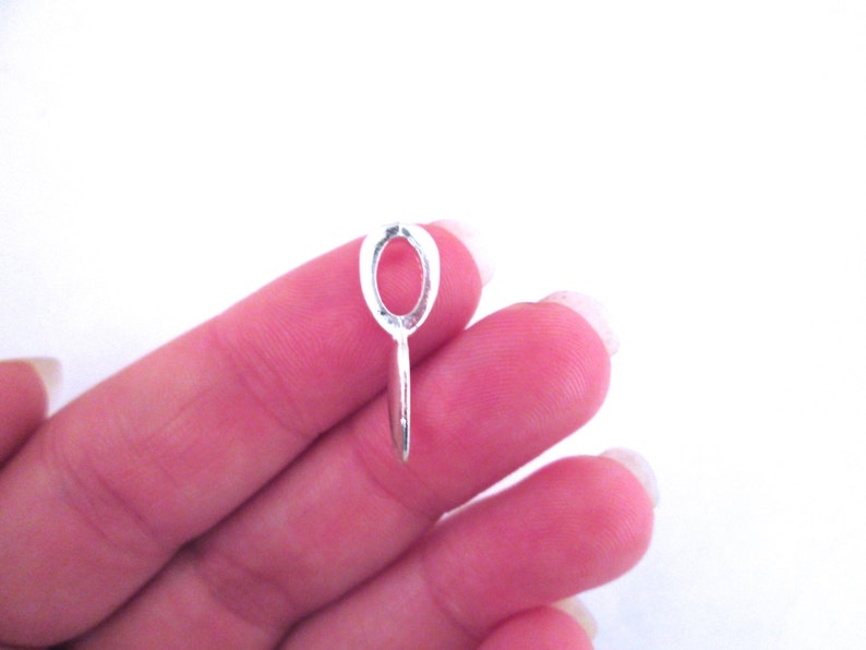 May include: Silver oval pendant bail with a loop on the bottom. The bail is designed to hold a pendant or charm.