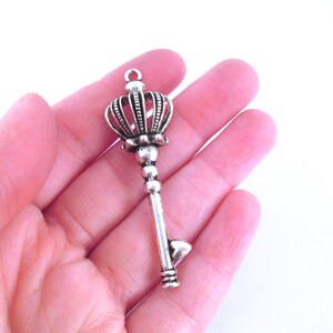 Puede incluir: Encanto de llave de plata con una parte superior en forma de corona. La llave tiene un corte en forma de corazón en la parte inferior.