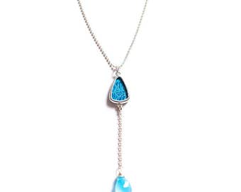 Shi Studio Plunge Necklace with turquoise silk brocade behind glass, sterling silver and faceted gem.