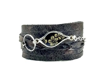 Multi strand leather wrap cuff with silk piece behind glass by Shi Studio
