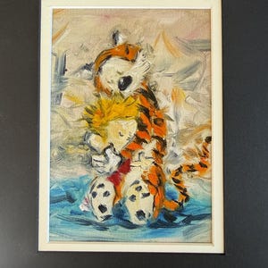 May include: An oil painting of Calvin and Hobbes, featuring the boy with yellow hair and the tiger in orange and black stripes. The artwork is framed in a white mat and set against a black background.