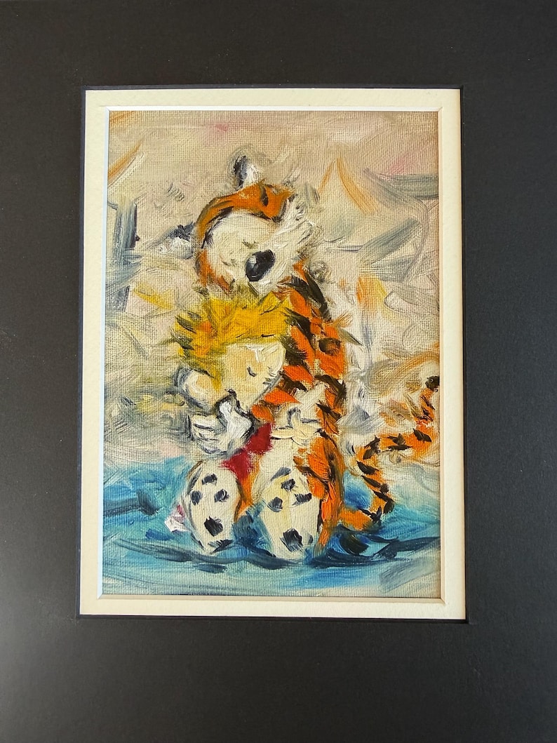May include: An oil painting of Calvin and Hobbes, featuring the boy with yellow hair and the tiger in orange and black stripes. The artwork is framed in a white mat and set against a black background.