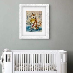 May include: A framed print featuring a watercolor illustration of a boy and a tiger hugging. The artwork is in a white frame and hangs above a white crib. The illustration has a blue, orange, and white color scheme.