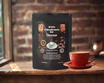Könnte beinhalten: Ein schwarzer Beutel mit einem weißen Etikett, auf dem "Hot Cocoa 9 Mushroom Blend Succus" und "Clarity and Focus" steht. Der Beutel liegt auf einer Holzoberfläche neben einer roten Tasse mit Kaffee.