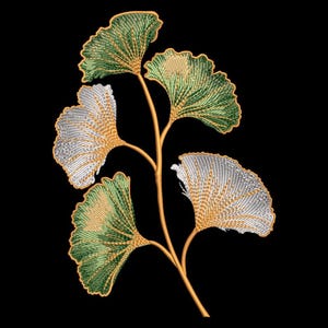 Può includere: Design ricamato di foglie di ginkgo nei toni del verde e dell'argento, con accenti dorati, su sfondo nero. Le foglie sono disposte su uno stelo dorato, mostrando cuciture dettagliate.