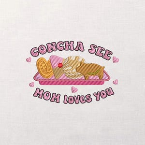 May include: Embroidered design showing a pink tray with a concha, a pretzel, and a pig-shaped pastry. The text "CONCHA SEE" and "MOM loves you" are in pink, with heart accents. The design is on a white background.