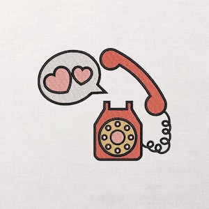 Pode incluir: Design bordado de um telefone retro vermelho com um cabo enrolado. Uma bolha de fala contém dois corações rosa. O mostrador do telefone é amarelo e rosa, com uma contorno preto. O design está em um fundo branco.