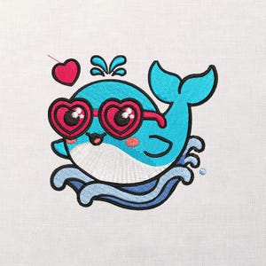 Pode incluir: Design bordado de uma baleia de desenho animado usando óculos de sol em forma de coração. A baleia é azul com barriga branca, bochechas rosadas e boca sorrindo. Um coração rosa flutua acima da baleia, cercado por água azul e respingos.