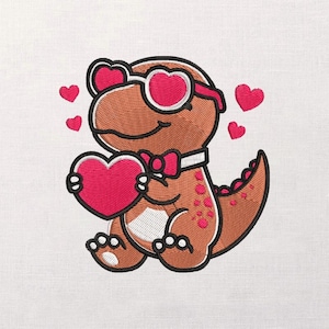 May include: Embroidered design of a cartoon dinosaur with heart-shaped sunglasses and a bow tie, holding a large pink heart. Several smaller pink hearts float around the dinosaur. The dinosaur is brown with pink spots and white accents, set against a white background.