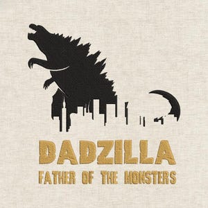 May include: A beige fabric item featuring a black silhouette of Godzilla towering over a city skyline. Below, the text "DADZILLA" and "FATHER OF THE MONSTERS" are embroidered in a gold color.