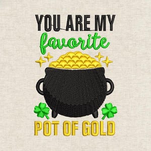 Puede incluir: Diseño bordado con una olla negra llena de monedas de oro, tréboles verdes y el texto "YOU ARE MY favorite POT OF GOLD" en negro, verde y dorado. Sobre un fondo de tela beige.