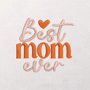 Pode incluir: Design bordado sobre um fundo branco. O texto "Best Mom ever" é exibido em uma mistura de fio pêssego e laranja. Um pequeno coração laranja está acima da palavra "Best". O design é provavelmente para o Dia das Mães.
