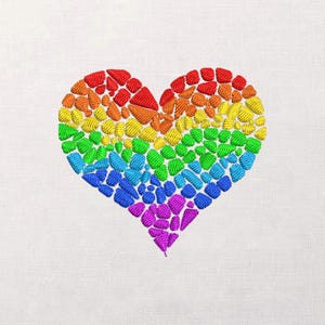 May include: Embroidered heart design in a rainbow of colors, including red, orange, yellow, green, blue, and purple. The heart is composed of small, textured stitches, creating a mosaic effect. The background is a plain white fabric.
