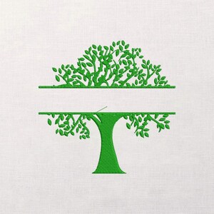 May include: Green embroidered tree design with a split horizontal line for personalization. The tree features a trunk and leafy branches, perfect for monogramming or adding a name. The design is on a white fabric background.