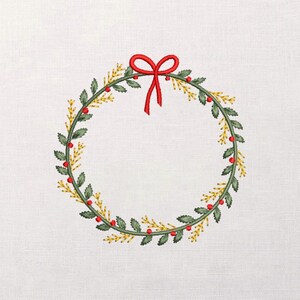May include: Embroidered Christmas wreath with green leaves, red berries, and gold accents. A red bow sits at the top. The wreath is on a white background.