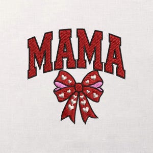 Könnte beinhalten: Gesticktes Design auf weißem Stoff. Das Wort „MAMA“ ist in roten Blockbuchstaben oben aufgebogen. Darunter befindet sich eine rote Schleife mit weißen Herzakzenten und rosa Innenschichten, die eine dekorative Note verleiht. Das Design ist wahrscheinlich für Kleidung oder Heimdekoration gedacht.