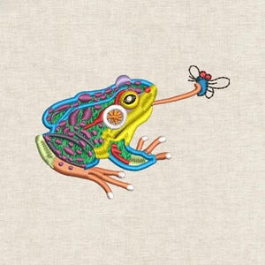May include: Embroidered frog design in blue, green, yellow, and purple. The frog has a long tongue reaching for a small fly. The design is on a beige fabric background.