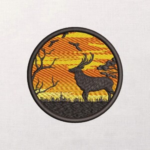 Puede incluir: Parche bordado con la silueta de un ciervo sobre un fondo de puesta de sol. El diseño incluye árboles, pájaros y un cielo texturizado naranja y amarillo, todo dentro de un borde circular negro. Para ropa o manualidades.