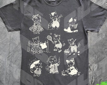 Może przedstawiać: Szary t-shirt z białym nadrukiem przedstawiającym 10 kotów wykonujących różne czynności. Koty są ubrane w ubrania i trzymają przedmioty takie jak parasole, grabie i rakiety tenisowe.