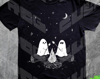 Może przedstawiać: Czarny t-shirt z białą ilustracją dwóch duchów piekących pianki nad ogniskiem. Projekt zawiera gwiaździste niebo i półksiężyc. Duchy siedzą na kłodzie. Koszulka ma wygodny krój.