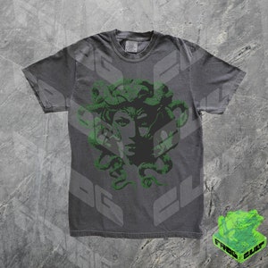May include: A dark grey t-shirt with a green print of Medusa's head with snakes for hair.