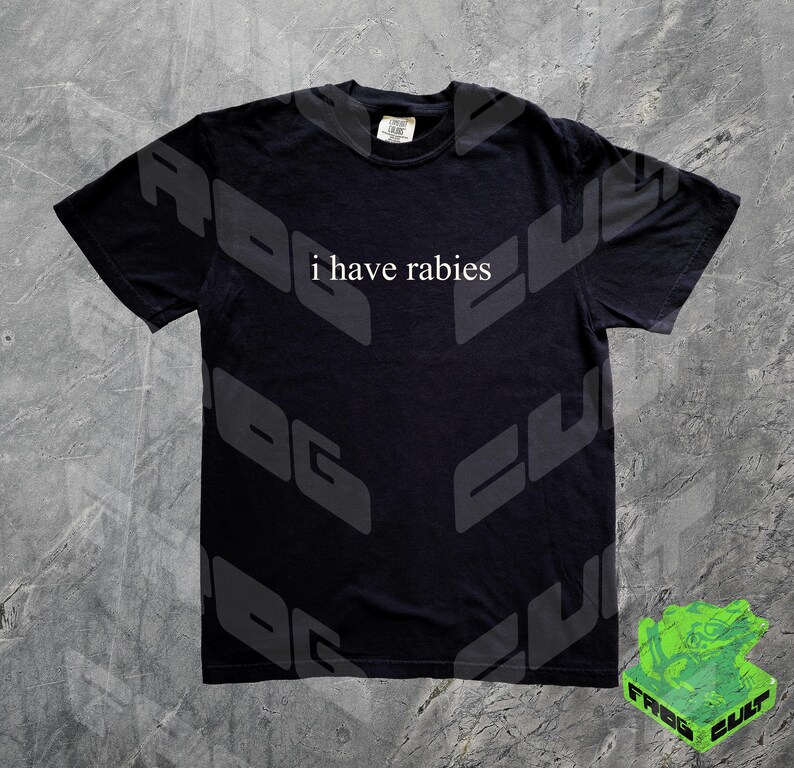 Może przedstawiać: Czarny T-shirt z nadrukiem "i have rabies" w kolorze białym na przodzie. Koszulka ma wyblakły, vintage'owy wygląd.