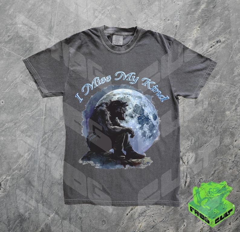 May include: A dark grey t-shirt with a graphic of a werewolf sitting under a full moon. The text "I Miss My Kind" is printed in white on the shirt.